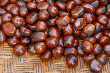 Chestnuts on woven wooden trays for sale at the market