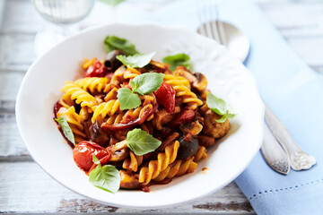 Pasta with cherry tomatoes, and olives. Bright wooden background. Close up.	