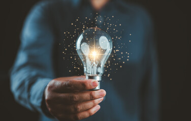 Businessman hands holding illuminated lightbulb for idea concept, idea, innovation and inspiration,...