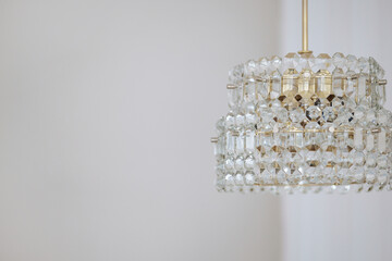 A chandelier with a gold base and a clear glass top. The chandelier is hanging from the ceiling and...