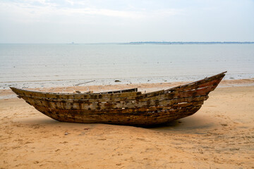 Close-up of abandoned wooden boat on the beach by the sea