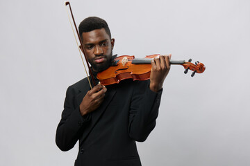 Talented African American man in elegant suit holding a violin isolated on white background