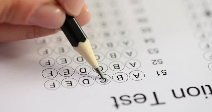 Student fills out exam test on answer sheet