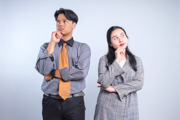 Young Businessman and Businesswoman Gesture Thinking and Looking Up Together Isolated on White Background 