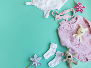 Set of pink clothes and accessories for newborn baby. Knitted toys rabbit and dog, romper, socks and handband