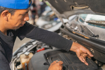 Mechanic examining a car in a rural garage