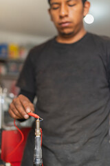 Mechanic checking battery on a car working at repair shop