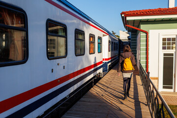 The girl is traveling. a young girl with a backpack walks along the station platform.