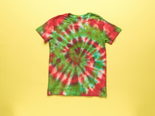Tie dye T-shirt on a bright yellow background.