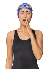 Young Caucasian female professional swimmer yawning showing a tired gesture covering mouth with...