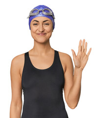 Young Caucasian female professional swimmer smiling cheerful showing number five with fingers.