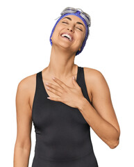 Young Caucasian female professional swimmer laughs out loudly keeping hand on chest.