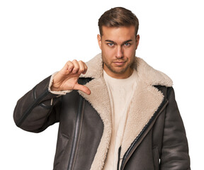 Young caucasian man showing a dislike gesture, thumbs down. Disagreement concept.