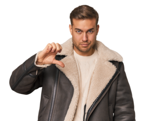 Young caucasian man showing a dislike gesture, thumbs down. Disagreement concept.