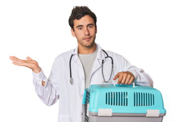 Young Hispanic man as vet with cage showing a copy space on a palm and holding another hand on waist.