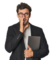 Young Hispanic businessman with laptop is saying a secret hot braking news and looking aside