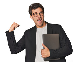 Young Hispanic businessman with laptop raising fist after a victory, winner concept.