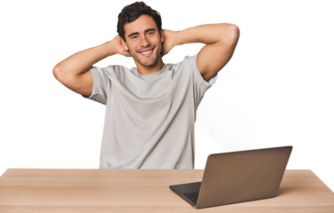 Hispanic young man working on laptop stretching arms, relaxed position.