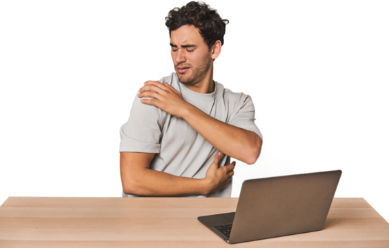 Hispanic young man working on laptop having a shoulder pain.