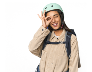 Hispanic young woman with mountain gear excited keeping ok gesture on eye.