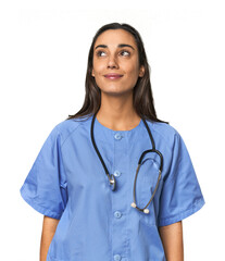 Hispanic nurse in uniform with stethoscope dreaming of achieving goals and purposes