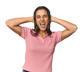 Hispanic young woman covering ears with hands trying not to hear too loud sound.