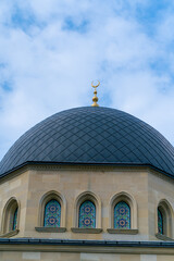 Close-up shot of the gambiz dome with a crescent moon on top of a Muslim mosque against a blue sky