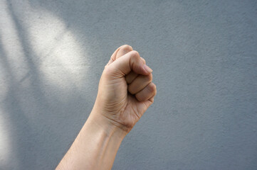 Male clenched fist, isolated on a grey background. Man hand with a fist