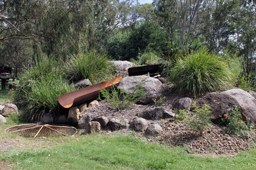 Water pipes, rocks and shrubs in a garden at the Tipperary Flats Rest Area in Nanango, Queensland,...