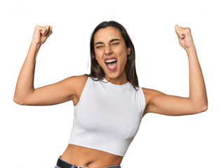 Hispanic young woman raising fist after a victory, winner concept.