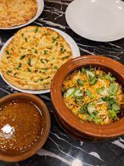 Claypot biryani rice served with flat bread Naan served on the table.