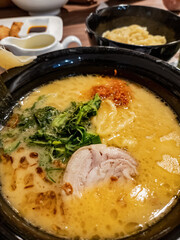 Japanese white broth ramen served with extra noodle and seaweed. Top view.