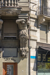 A statue in the facade of a historical building with a classic man and a lion head. Lucerne, Switzerland.