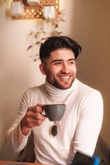 Portrait of colombian young man holding a coffee cup and smiling.