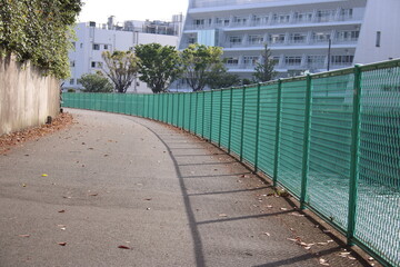 河川堤防沿いの金網と道路