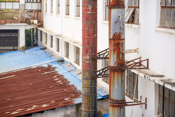 Rusty industrial workshop buildings and chimneys in an old industrial area
