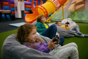 Little children playing video game in entertainment center