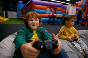 Portrait of excited boy with surprise and joy on face playing video game