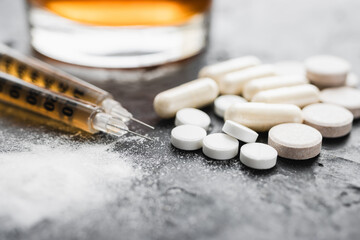 Narcotic substances, dope powder, syringes with drugs dose, white pills and glass of alcohol drink...
