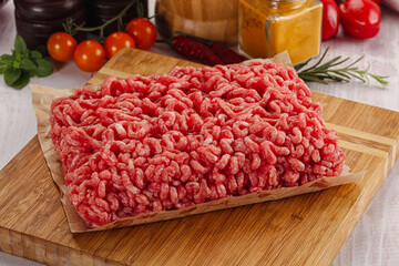 Raw minced beef meat over board