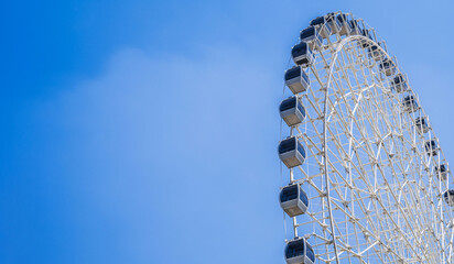 white big Ferris wheel on background a clear blue sky in fair in summer with copy space