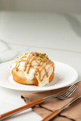Cinnamon roll bun with icing on plate