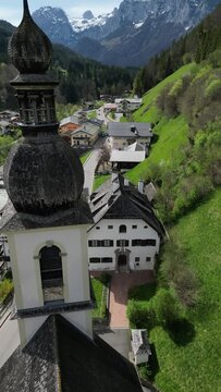 Bavarian Ramsau Berchtesgaden view along a church and icy cold mountain river with the Watzmann mountain chain at the background