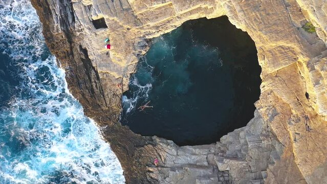 Slow motion aerial view of girl floating in Giola natural sea pool Thassos island, Greece
