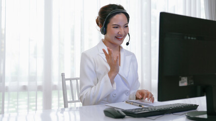 Businesswoman wearing vivancy headset working in office to support remote customer or colleague. Call center, telemarketing, customer support agent provide service on telephone video conference call