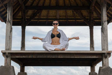 A woman in a meditative yoga pose in a Balinese pavilion, creating a picture of tranquility and balance Tranquil Yoga Pose