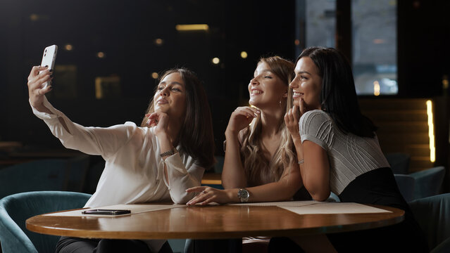 Positive girls best friends sitting in a cafe and chatting, colleagues partners gathered in a restaurant during lunch, talking, enjoying conversation, communication, good warm relationship concept