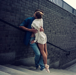 partner in love hugs a ballerina on the city stairs while walking around the city on a summer day