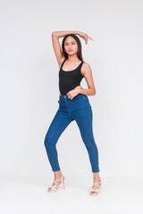 Front view of a young asian woman in a black bodysuit and jeans Isolated on a white background....
