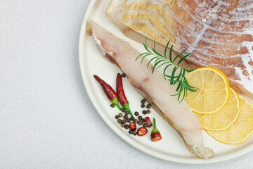 Raw pollock (Pollachius virens) fillet. Fresh fish for healthy food lifestyle. Spices and herbs